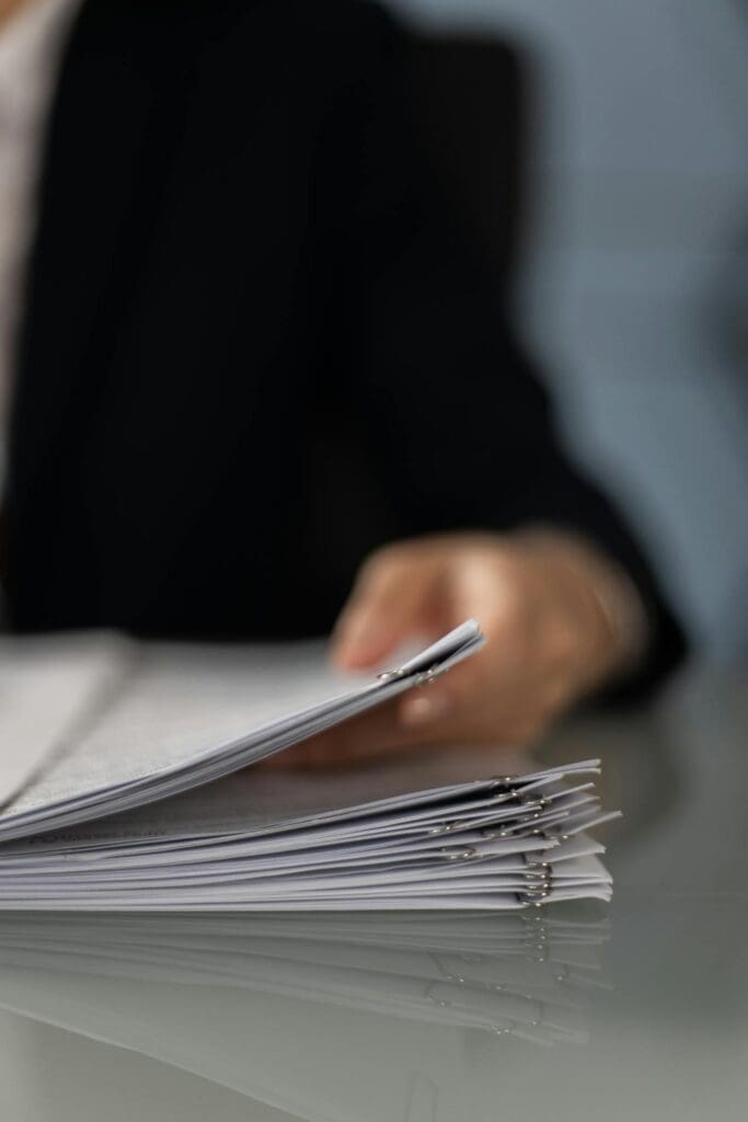 A small business owner meticulously sorting through SBA loan application paperwork, an essential part of the process for owner-user commercial real estate Reno acquisitions.